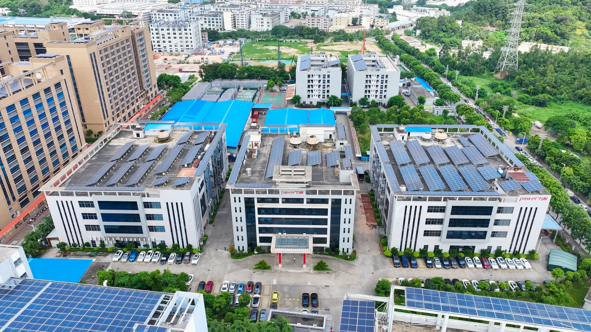 三栋带有 Power 力辉标识的园区建筑与屋面光伏航拍全景